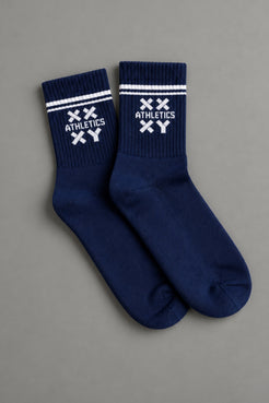 Pair of navy blue socks with white accents on a gray background || navy
