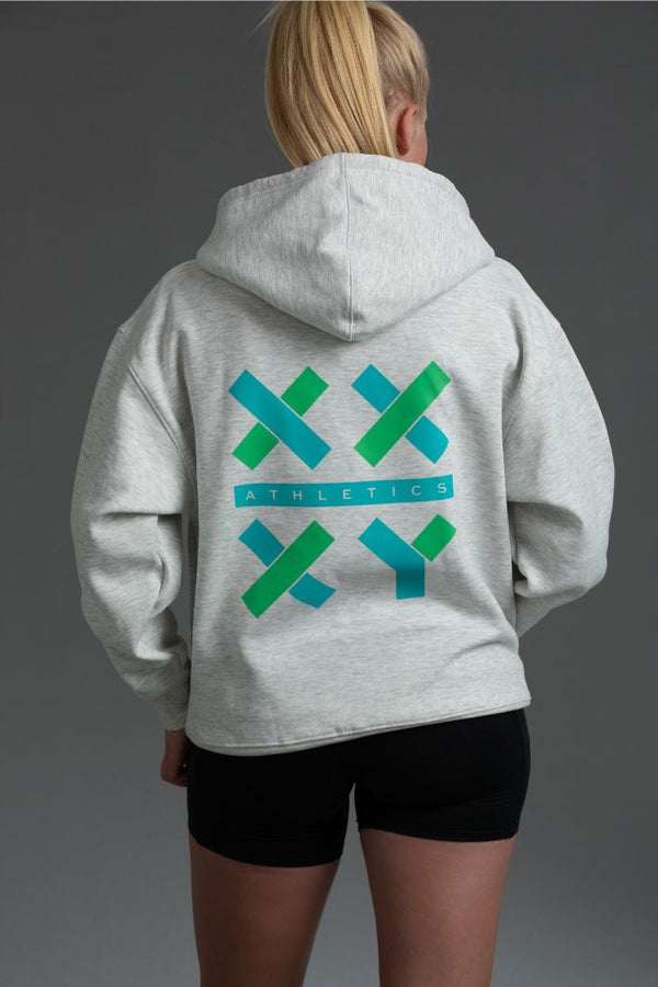 Person wearing a gray hoodie with green and blue logo on the back || Light Heather Gray