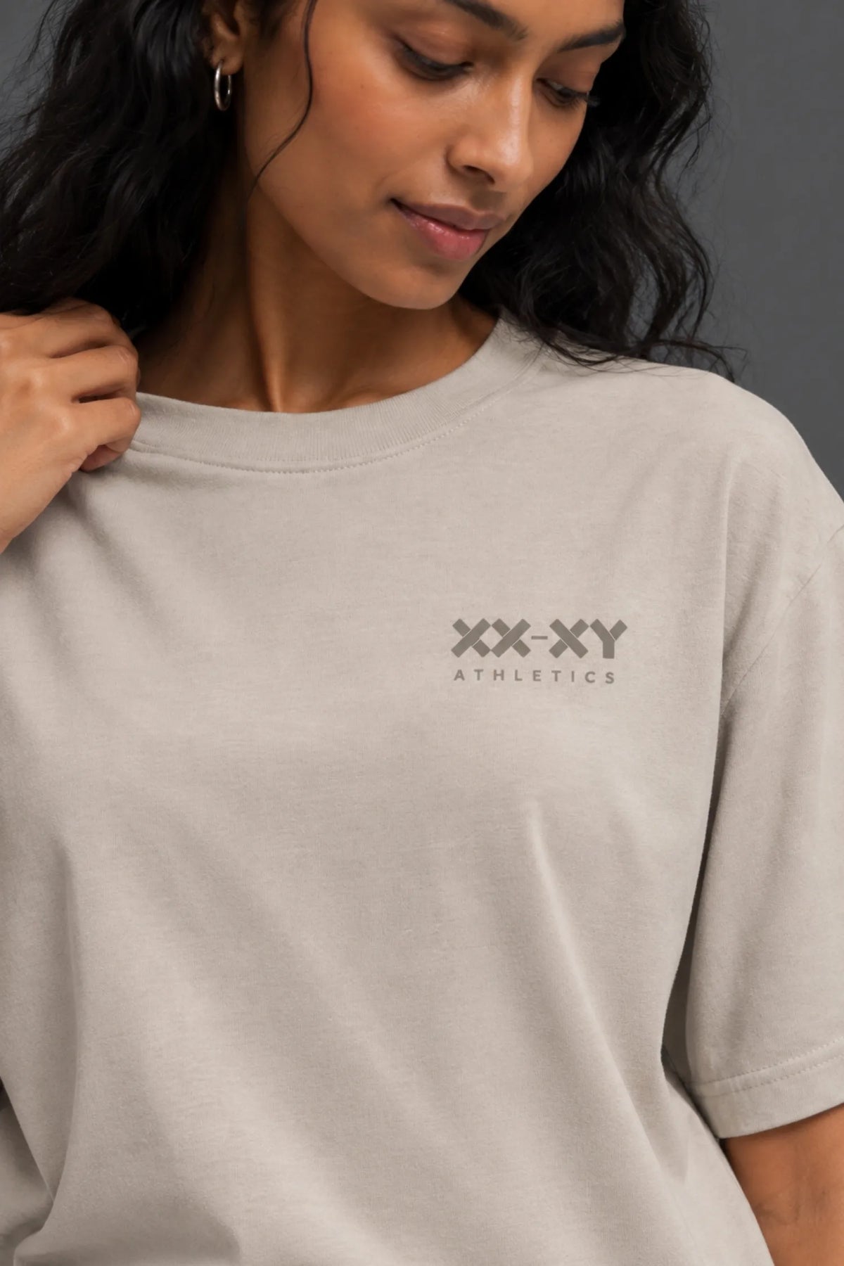 Close-up of stone XX-XY Athletics T-shirt with tonal logo on the front chest.