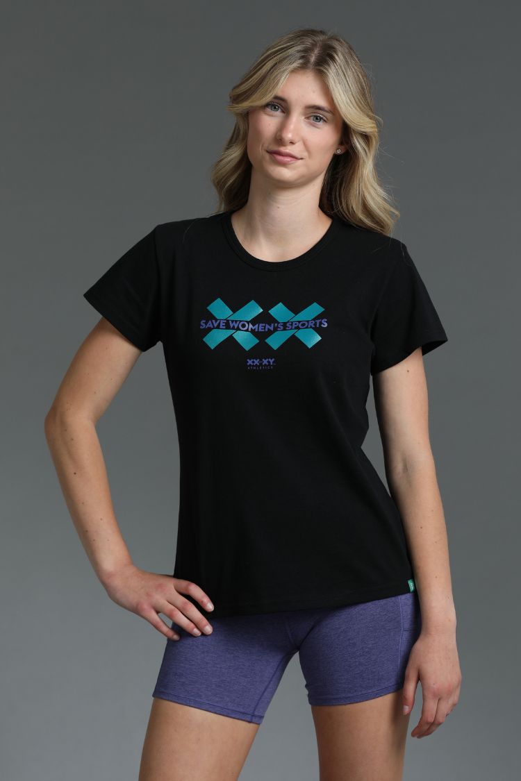 Woman wearing a black t-shirt with a blue logo on a gray background || Teal
