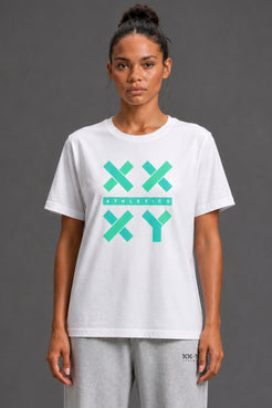 A woman modeling a white short-sleeve athletic T-shirt with a teal geometric logo and the word 'ATHLETICS' on the chest, paired with light gray sweatpants against a dark gray studio background. || White