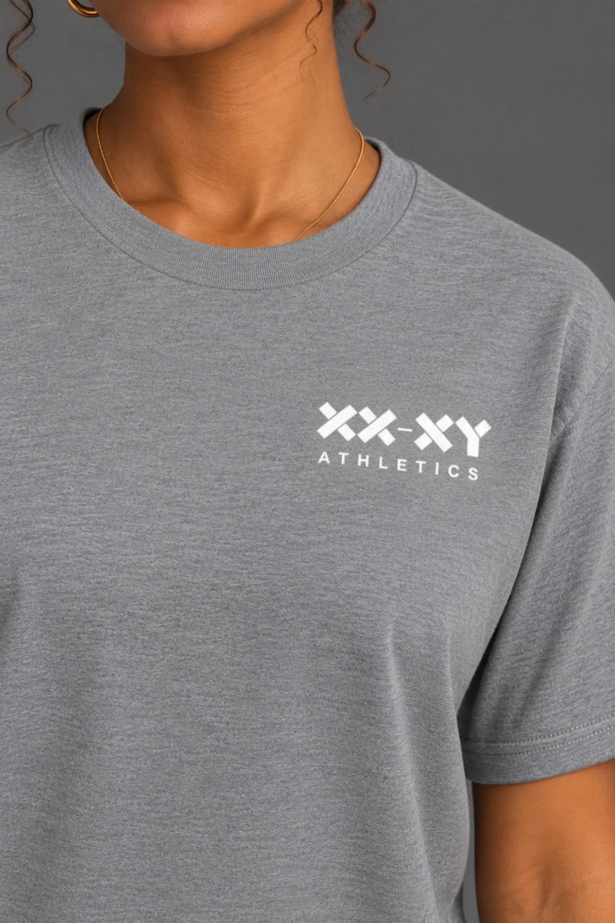 Close-up of the white XX-XY Athletics chest logo on a heather gray boyfriend-fit tee.