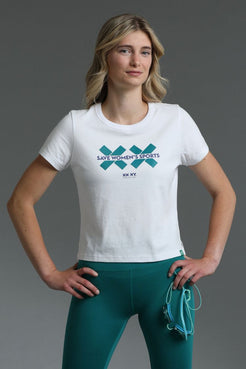 Woman wearing a white t-shirt with a logo and teal leggings on a gray background || Teal