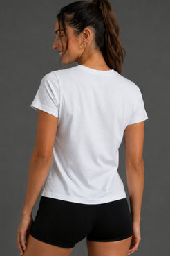 A woman shown from the back wearing a plain white short-sleeve crewneck T-shirt and black athletic shorts against a dark gray studio background. || White