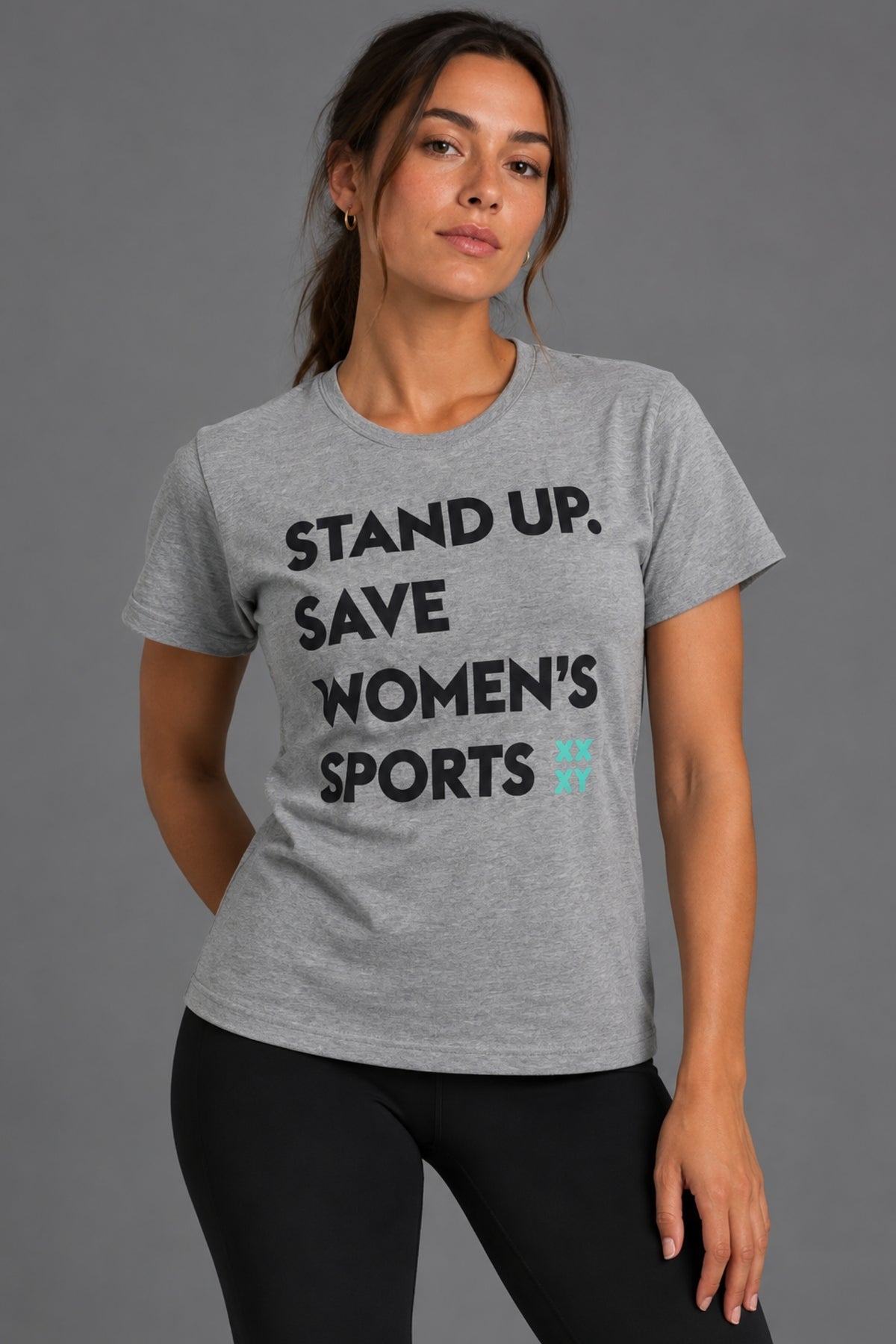 Woman wearing the gray Stand Up Save Women’s Sports graphic tee with black leggings
