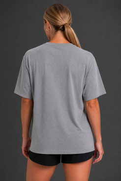 A woman viewed from the back wearing a heather gray short-sleeve t-shirt and black athletic shorts against a dark gray studio background. || Heather Gray
