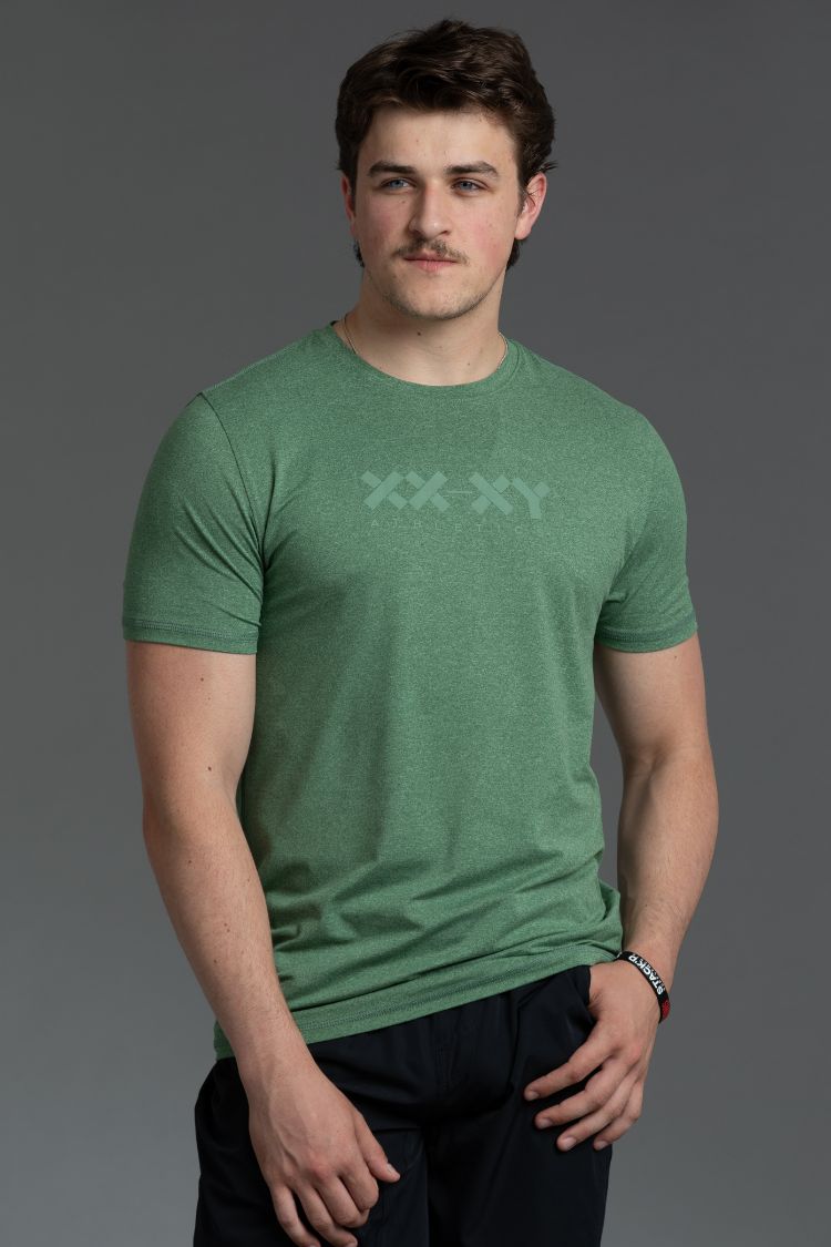 Man wearing a green t-shirt with a xx-xy logo on a gray background || Hunter Green Heather