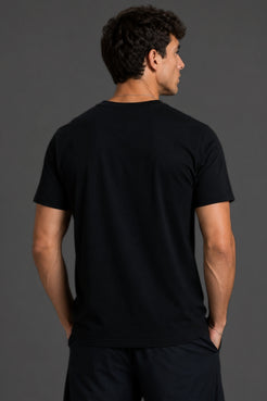 A man wearing a plain black short-sleeve crewneck t-shirt, shown from the back against a dark gray studio background. || Black Tonal