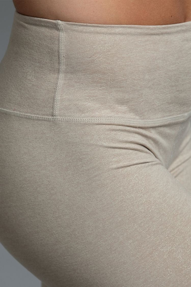 Close-up of beige leggings with a focus on texture and fit. || shimmery taupe