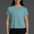 Woman wearing a light blue t-shirt with a logo on a gray background || Underseas
