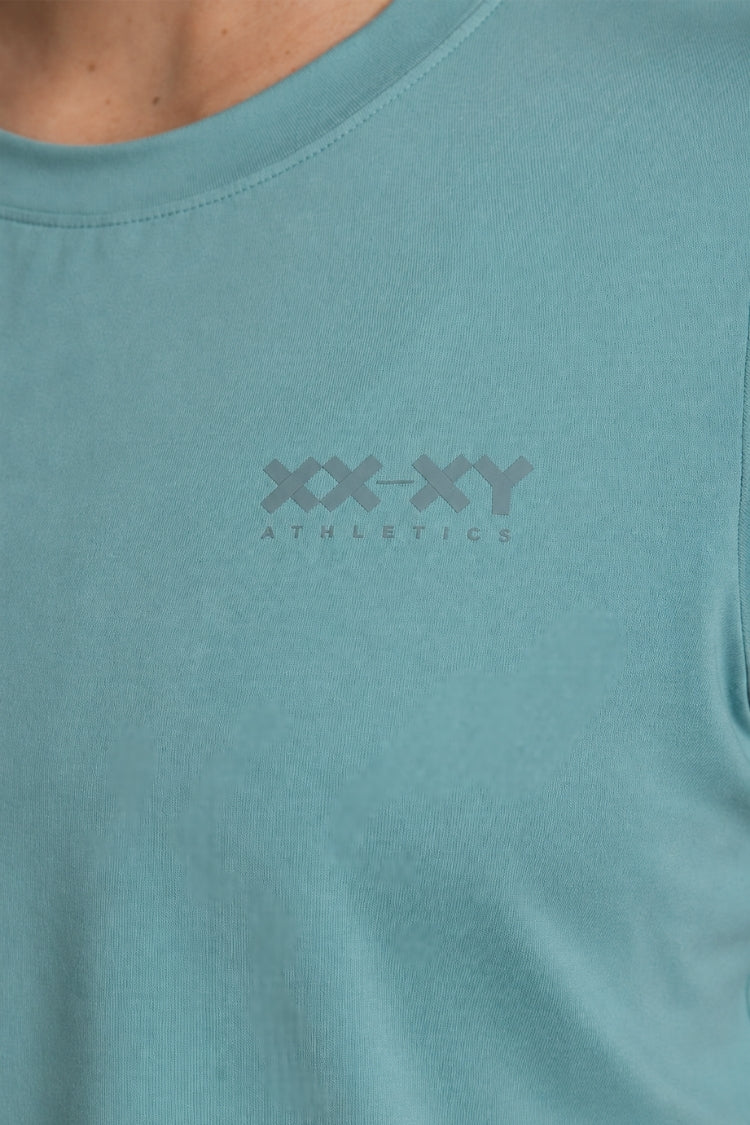 Teal t-shirt with 'XX-XY Athletics' logo on a person wearing it. || Underseas