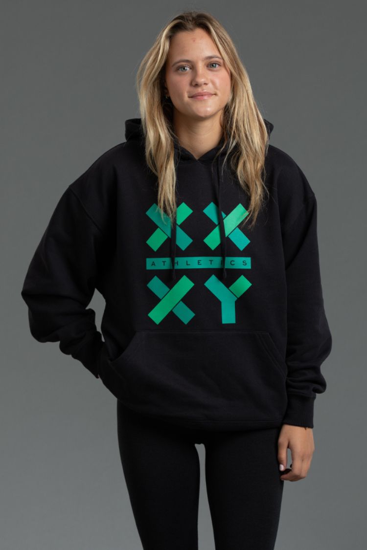 Person wearing a black hoodie with green geometric design on a gray background || Black