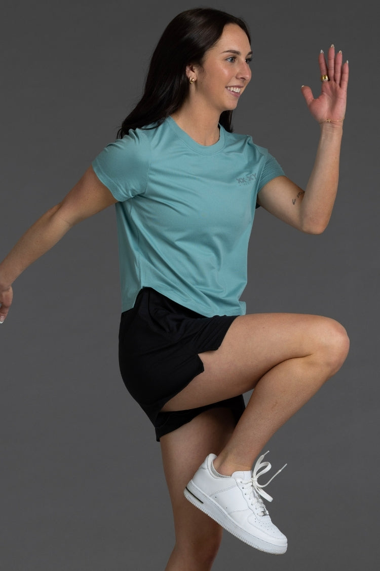 Woman in athletic wear posing against a gray background || Underseas
