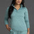 Woman wearing a teal long-sleeve top and pants against a gray background || Underseas