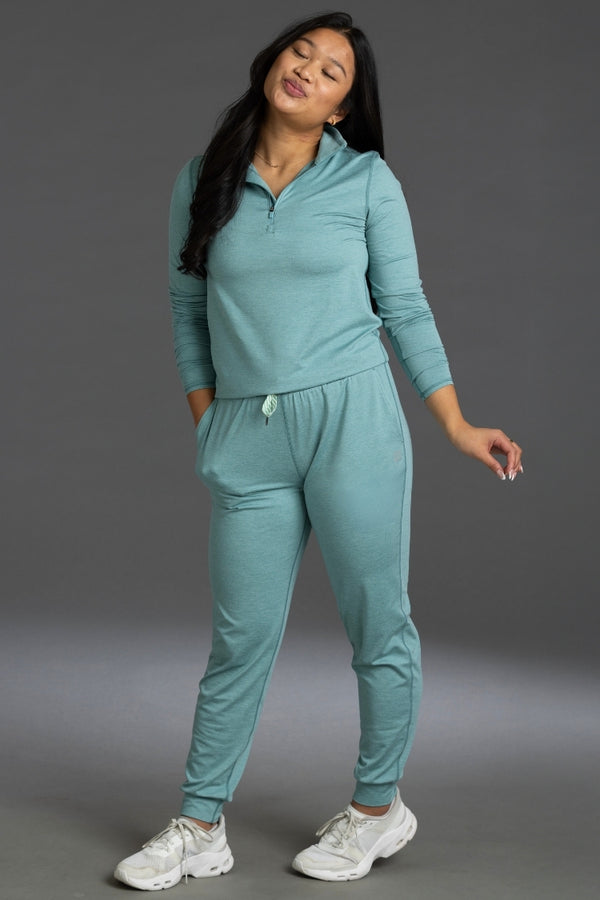 Woman wearing a teal tracksuit against a gray background || Underseas