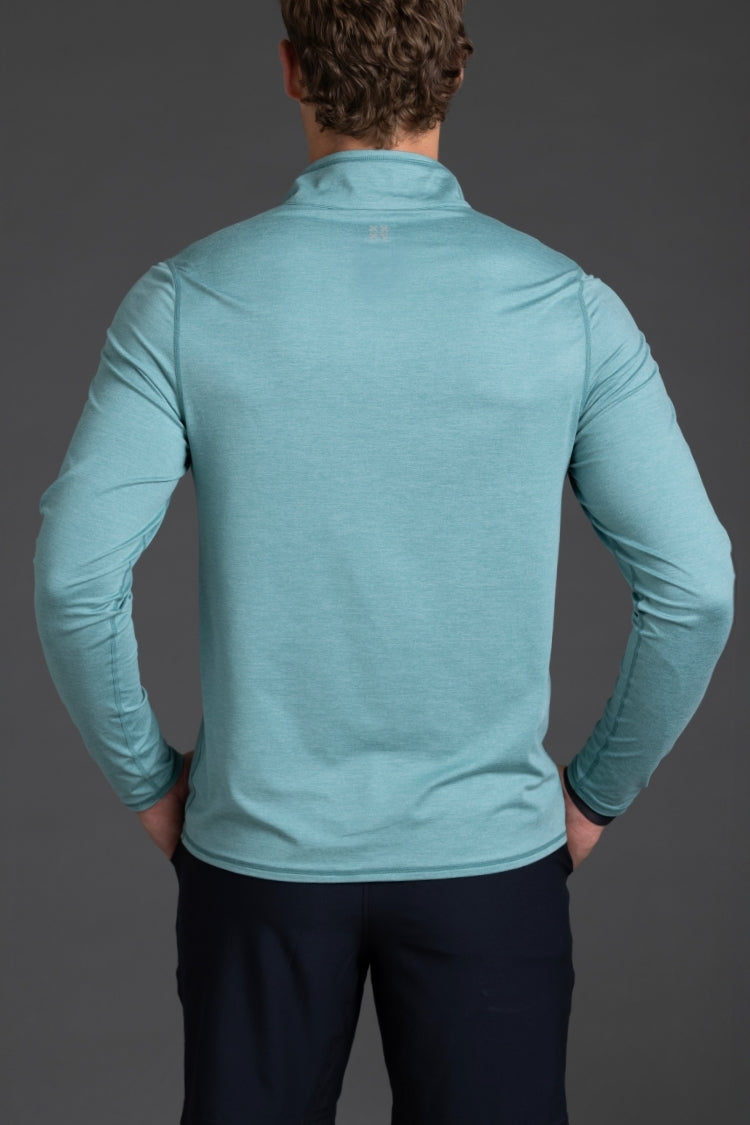 Person wearing a teal long-sleeve shirt against a gray background || Underseas