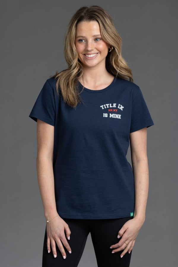 Woman wearing a navy blue t-shirt with text on a gray background || Navy