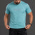 Man wearing a turquoise t-shirt with a logo and black shorts on a gray background || Underseas