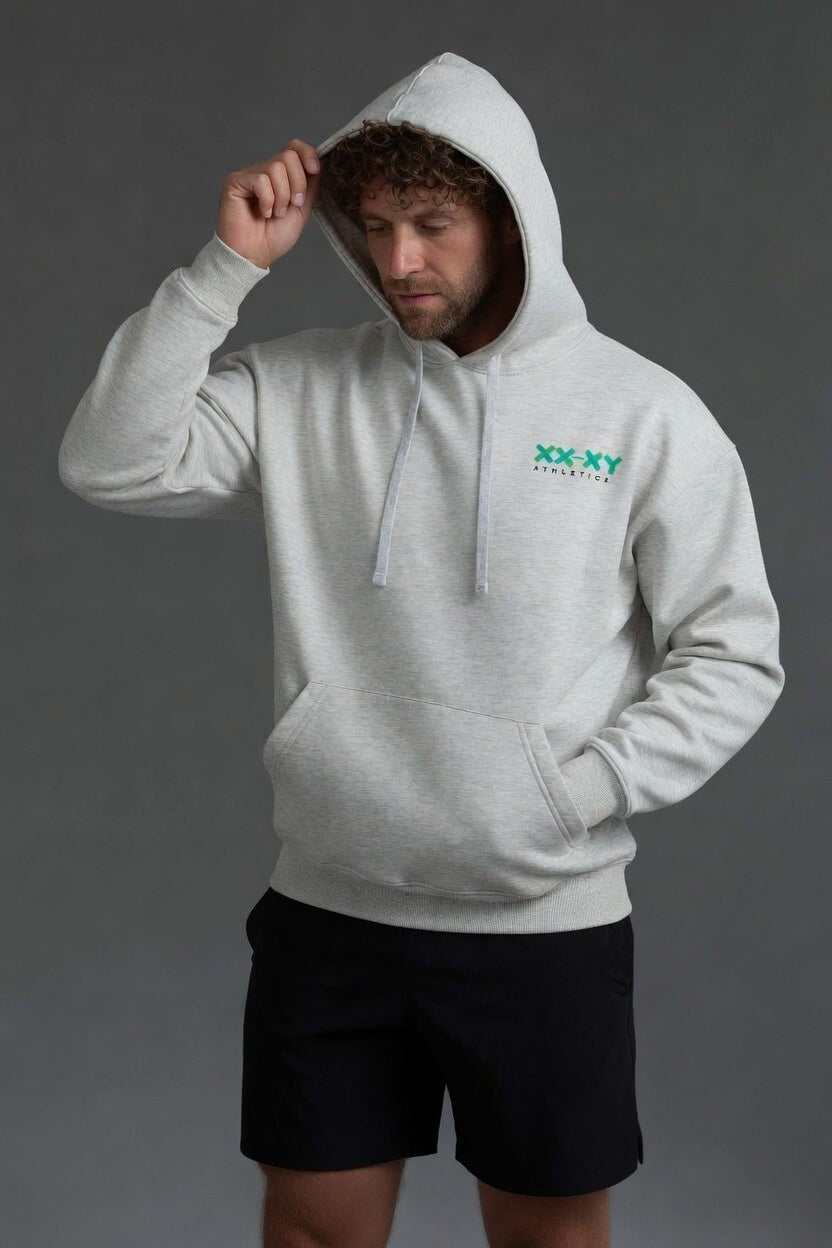 Person wearing a gray hoodie with a logo on a dark background || Light Heather Gray