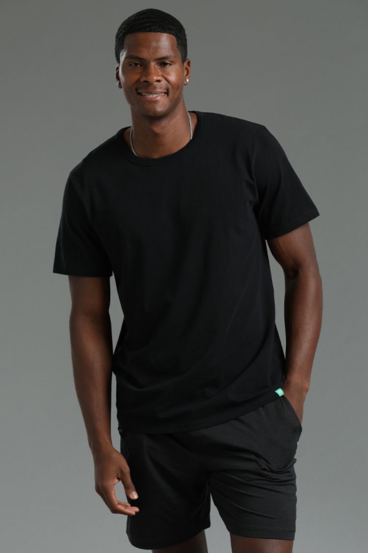 Man wearing a black t-shirt and shorts on a gray background || black