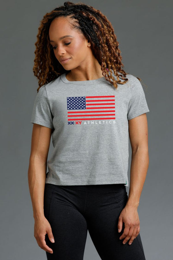 Woman wearing a gray t-shirt with an American flag design || Light Heather Gray