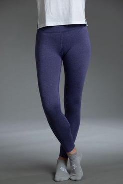 Person wearing Indigo leggings and gray socks on a gray background || Indigo