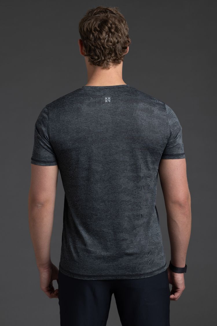 Man wearing a dark gray t-shirt against a gray background || Black