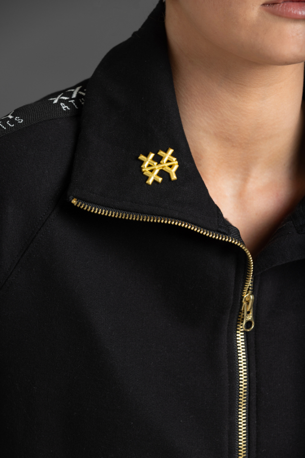 Black jacket with gold zipper and a yellow XXXY brooch || Gold