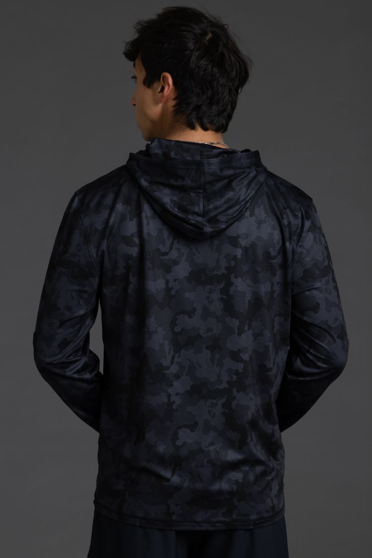 Person wearing a dark camouflage hoodie on a gray background || Black Camo