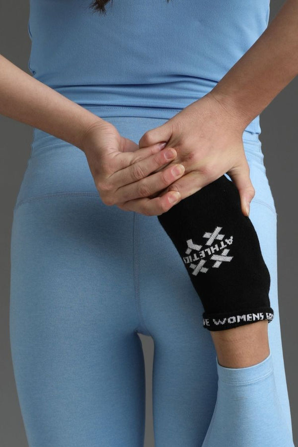 Person wearing a black knee pad with a logo on a gray background || black