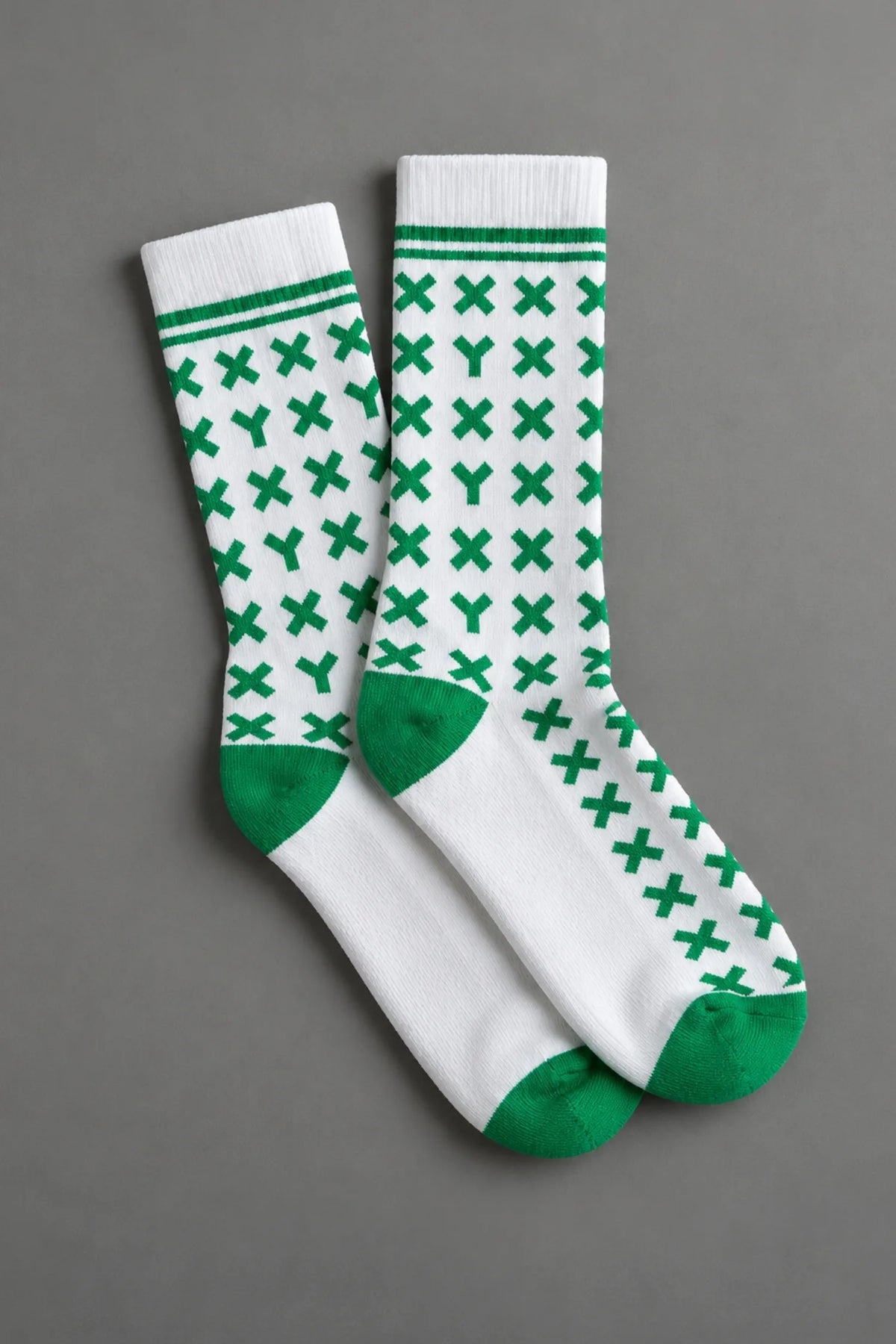 Pair of white socks with green pattern on a gray background || kelly green