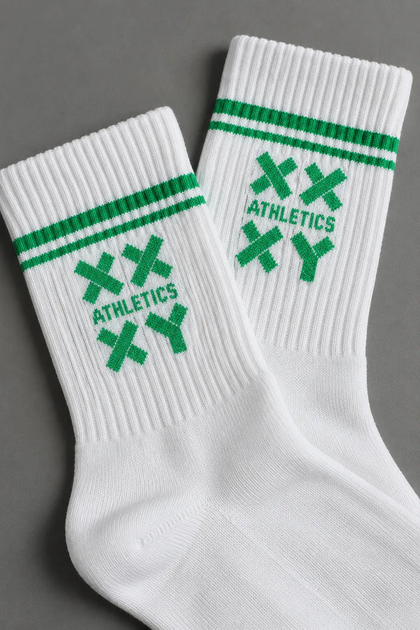 Close-up of white XX-XY Athletics crew socks featuring white stripes and a white knit logo. || White