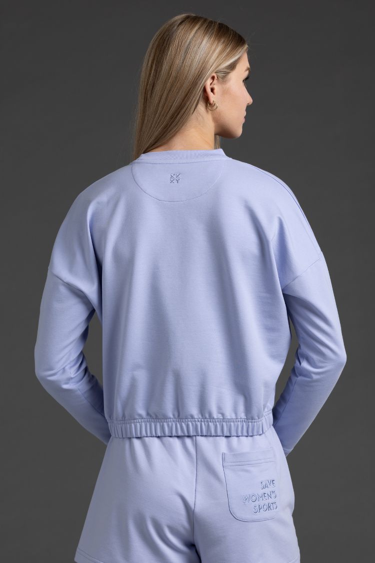 Person wearing a Lavender Gray tracksuit with brand logo on a dark gray background || Lavender Gray