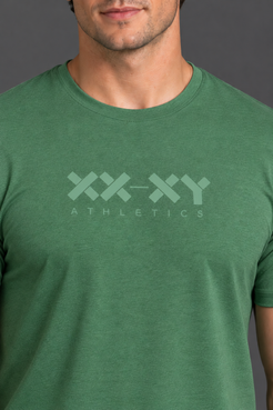 A close-up of a man wearing a heather green crewneck t-shirt with a light green 'XX-XY ATHLETICS' logo printed on the chest, set against a dark gray background. || Hunter Green Heather