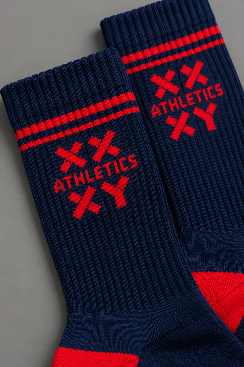 Pair of blue socks with red accents on a gray background || blue aster/red
