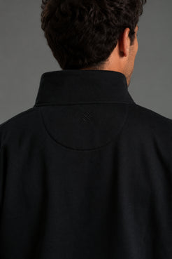 Person wearing a black jacket and shorts on a gray background || Black