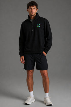 Person wearing a black pullover with a logo on a gray background || Black