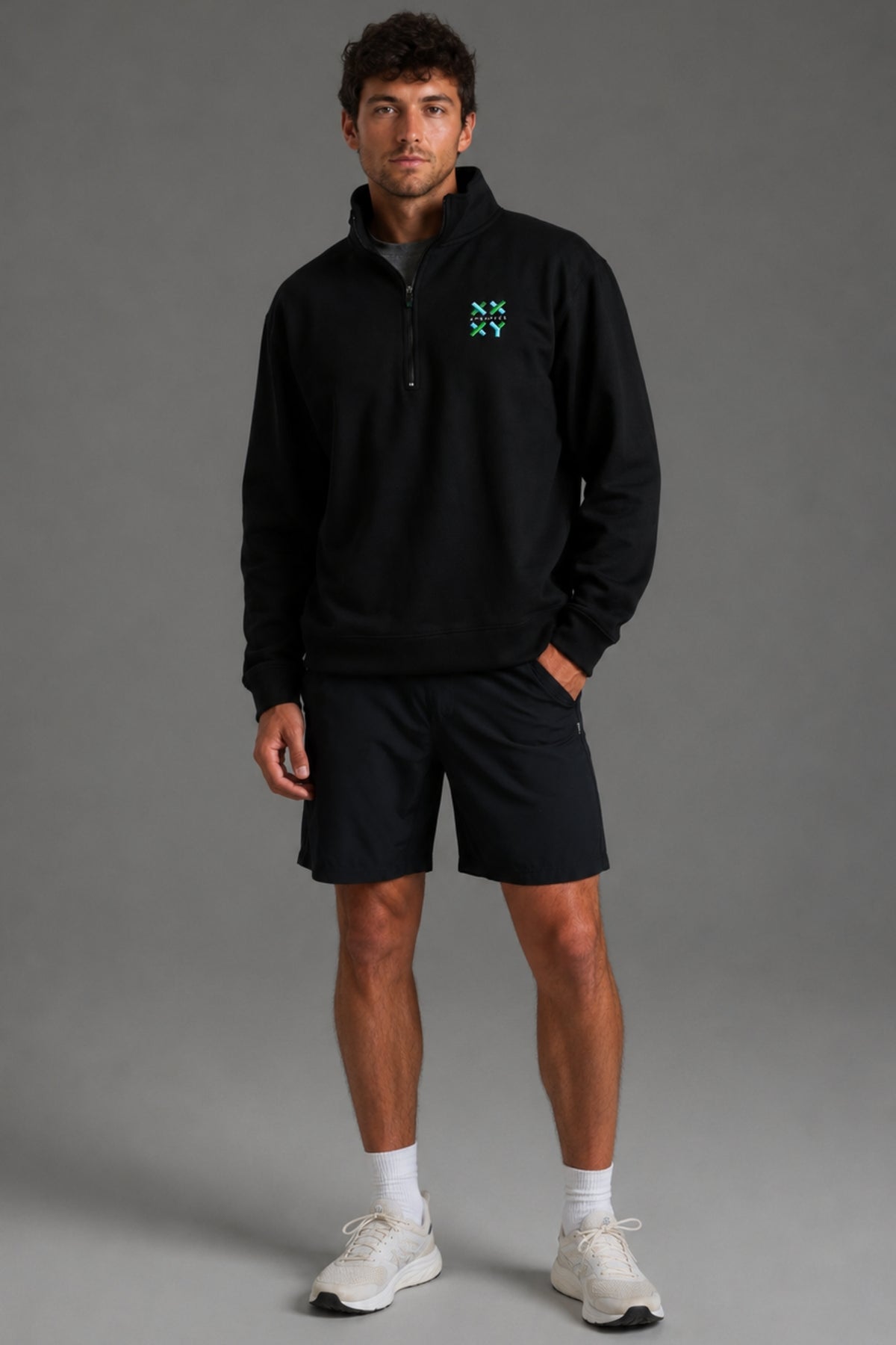 Person wearing a black pullover with a logo on a gray background || Black
