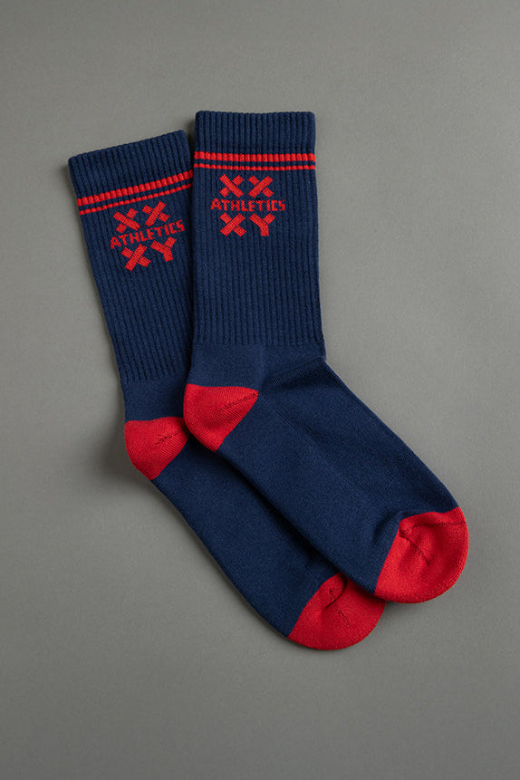 Pair of blue socks with red accents and branding on a gray background || blue aster/red