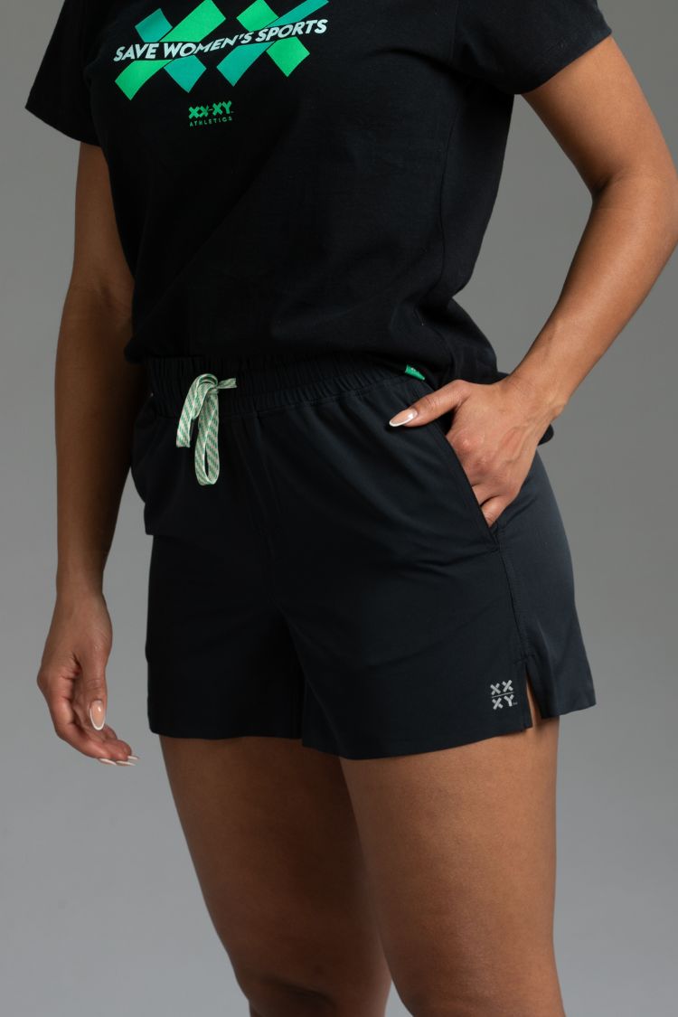 Person wearing a black outfit with green accents on a gray background || black