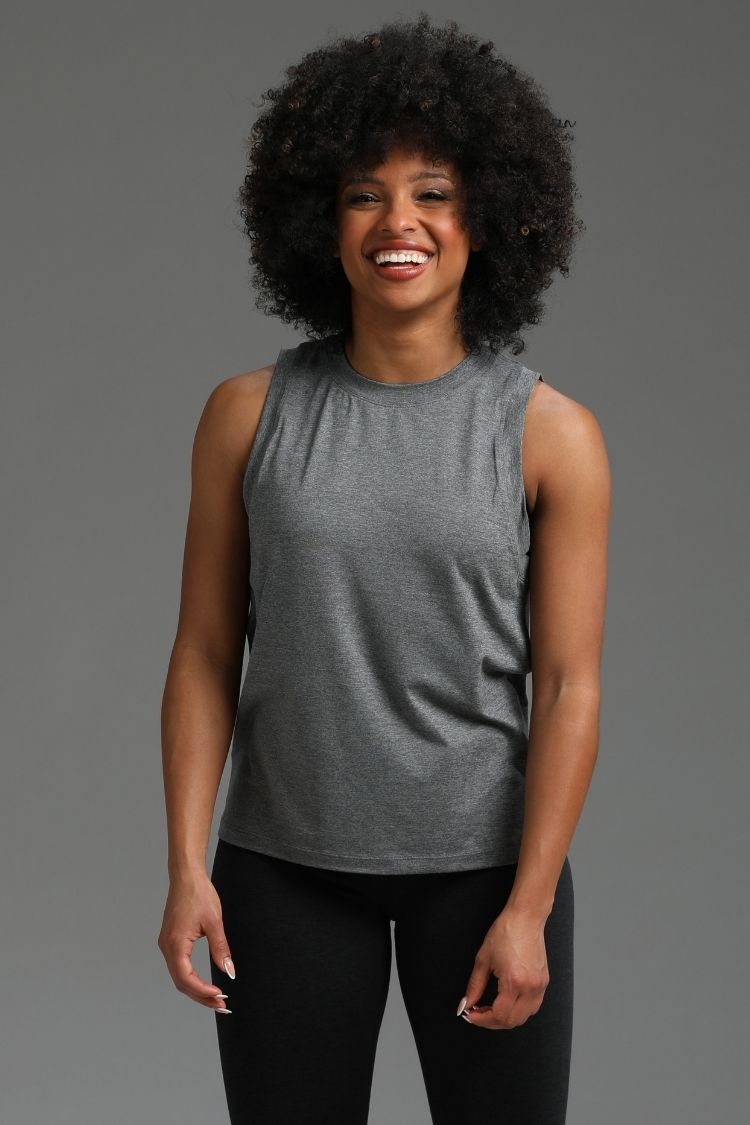 Woman wearing a gray sleeveless top and black pants against a gray background || dark heather gray