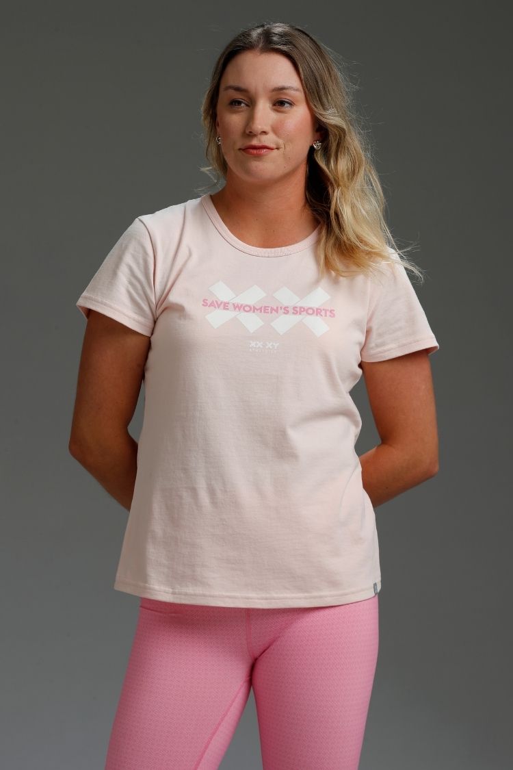Woman wearing a light-colored t-shirt with text and pink leggings || light pink