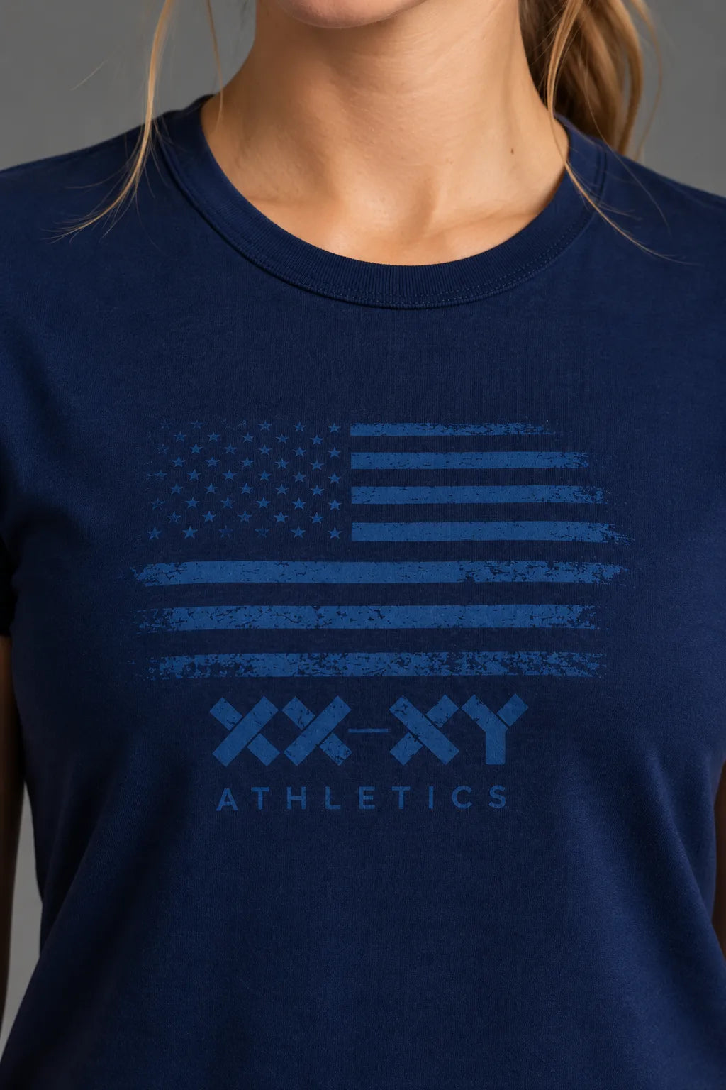 Close-up of the tonal American flag and XX-XY Athletics graphic on a navy women’s tee.