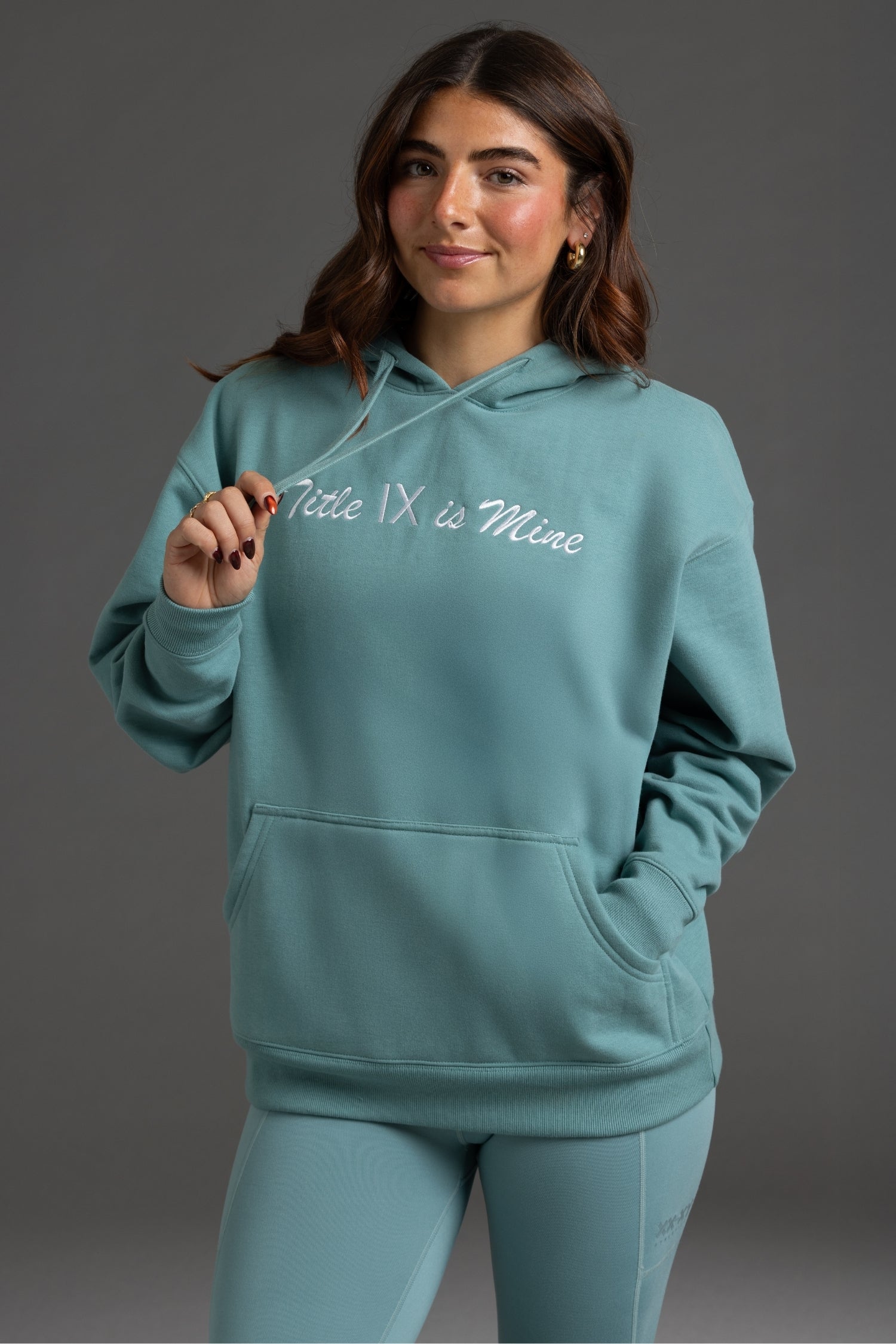 Person wearing a teal hoodie and leggings with text on a gray background || Underseas