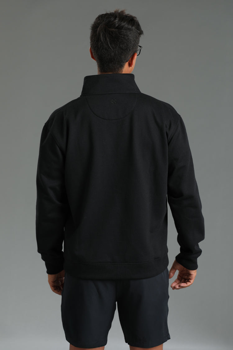Person wearing a black jacket and shorts on a gray background || Black
