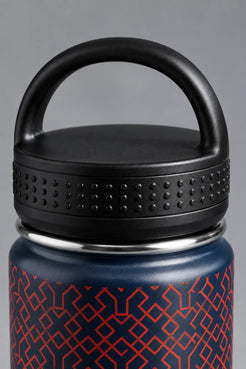 Close-up of a black loop-handle water bottle lid with textured grip detailing on a navy XX-XY Athletics bottle with a red geometric pattern. || Navy Patriotic