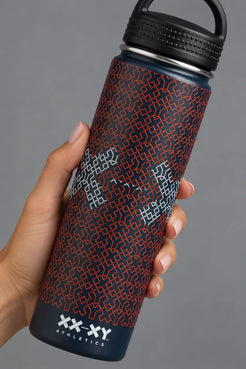 A 32 oz insulated stainless steel water bottle by XX-XY, featuring a dark navy blue body with a red geometric pattern and white geometric accents, topped with a black lid and carrying loop, set against a neutral gray background. || Navy Patriotic