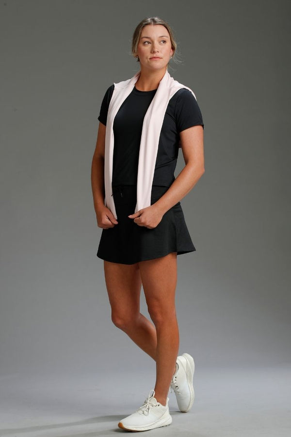 Woman in black athletic outfit with white sneakers on a gray background || black