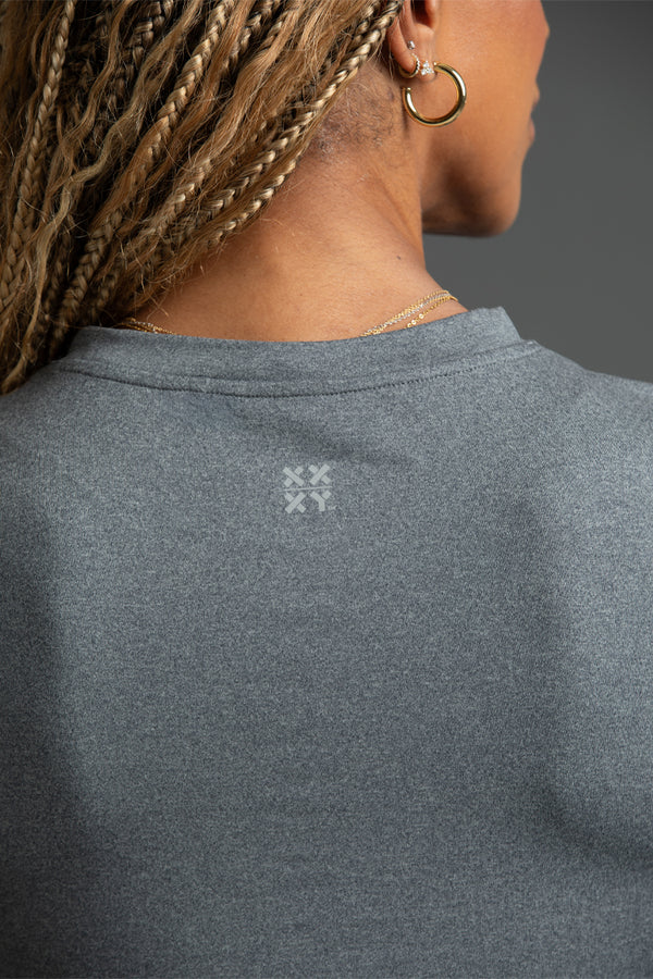 Dark Grey sweatshirt with a logo on the back, worn by a person with braided hair. || Dark Heather Gray
