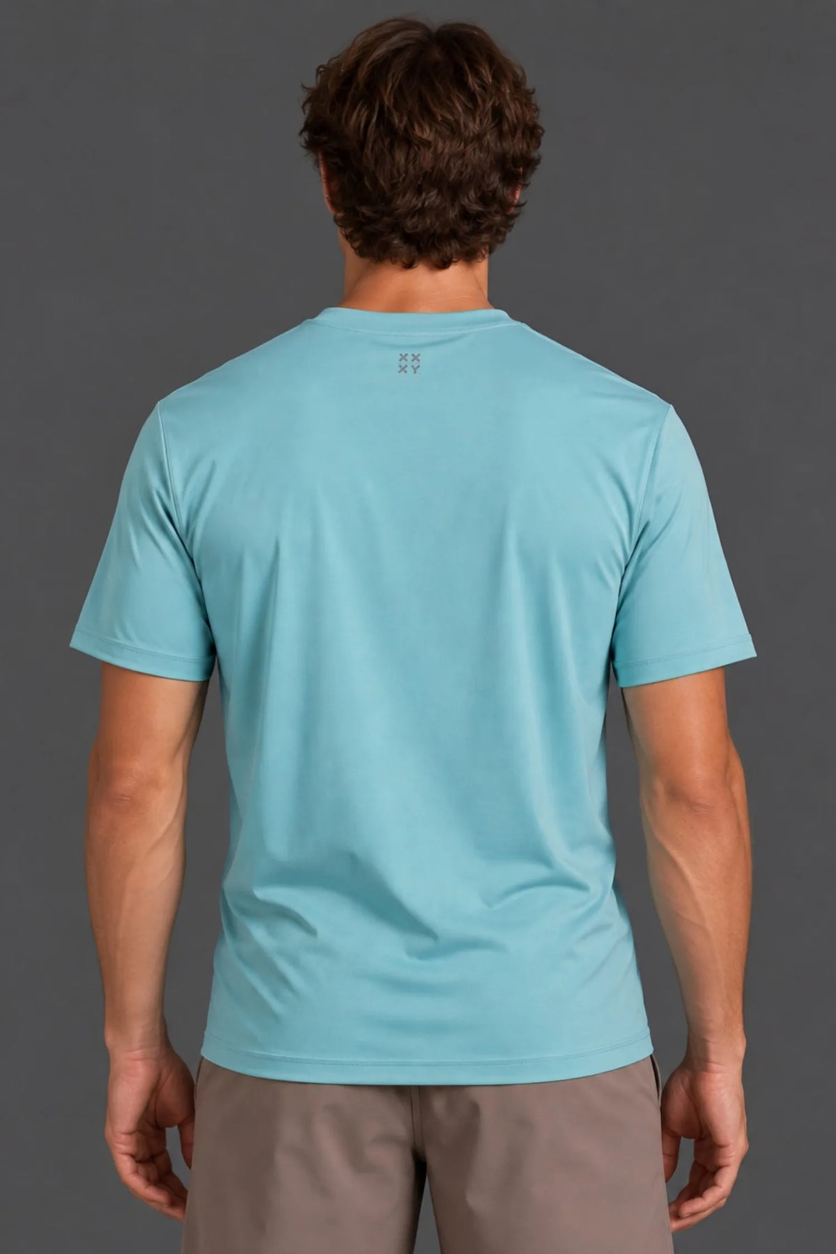 Back view of male model wearing the light blue XX-XY Athletics Logo Tee with mocha athletic shorts.